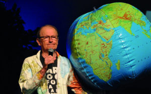 George Verwer next to a world globe